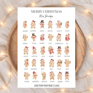 Puede incluir: Una impresión rectangular blanca con el texto MERRY CHRISTMAS, Mrs Brooks y LOVE FROM YOUR YEAR 2 CLASS. El diseño incluye una cuadrícula de treinta figuras de pan de jengibre en acuarela, cada una etiquetada con un nombre como Amaya, Sophie y Maks.