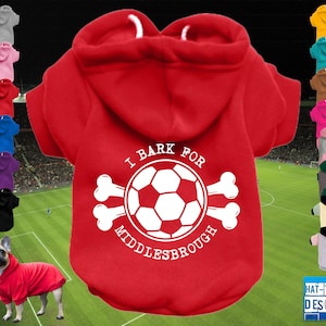 Könnte beinhalten: Roter Hunde-Hoodie mit Kapuze und dem Text "I Bark for Middlesbrough" umgeben von einem Fußball und gekreuzten Knochen. Zusätzliche Farboptionen werden angezeigt.