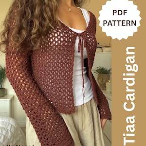 Könnte beinhalten: Eine braune, langärmelige Häkelstrickjacke mit offenem Vorderteil und einem dünnen Bindeband am Ausschnitt. Das Kleidungsstück weist ein sich wiederholendes Lochmuster auf. Der Text lautet PDF PATTERN, Tiaa Cardigan und No AI used.