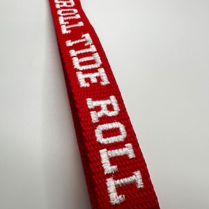May include: Red fabric strap with white embroidered text that reads "GOLD TOE"