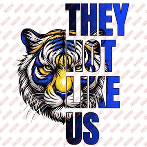 Puede incluir: Diseño gráfico impactante con la cara de un tigre en azul, amarillo y blanco. El texto "THEY NOT LIKE US" está superpuesto en azul y blanco, creando un efecto visual audaz.