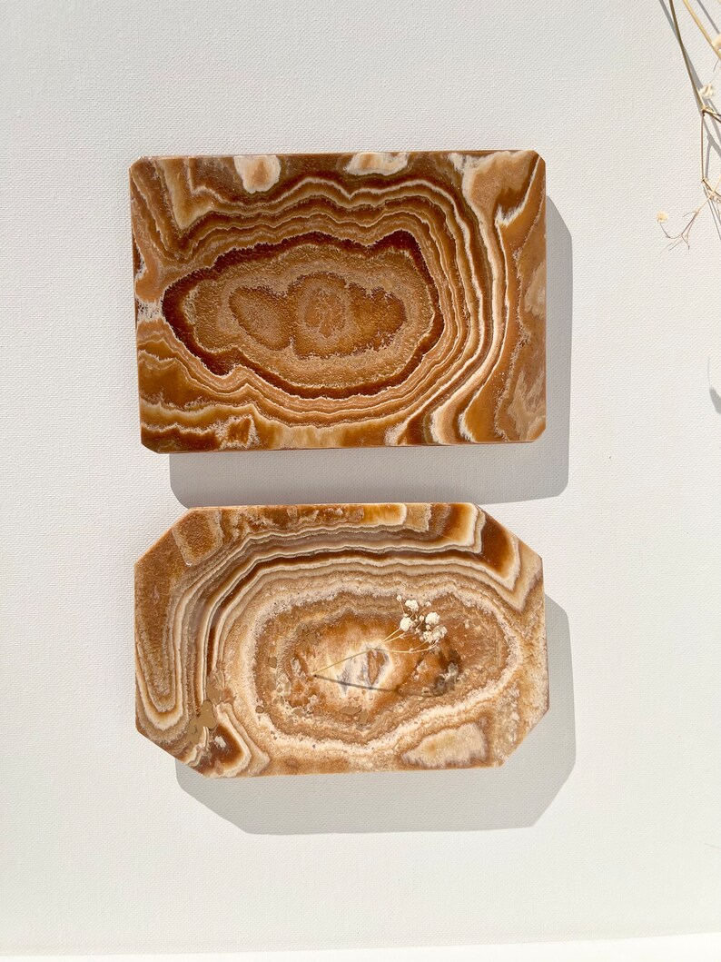 May include: Two rectangular onyx trays with a brown and white swirl pattern. The trays are made of natural stone and have a smooth, polished finish.