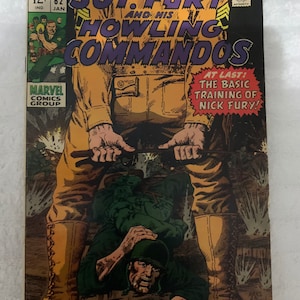 Puede incluir: Una portada de cómic con un soldado con uniforme marrón con las palabras "Sgt. Fury and his Howling Commandos" en letras grandes y en negrita. La portada también incluye el texto "At Last: The Basic Training of Nick Fury!"