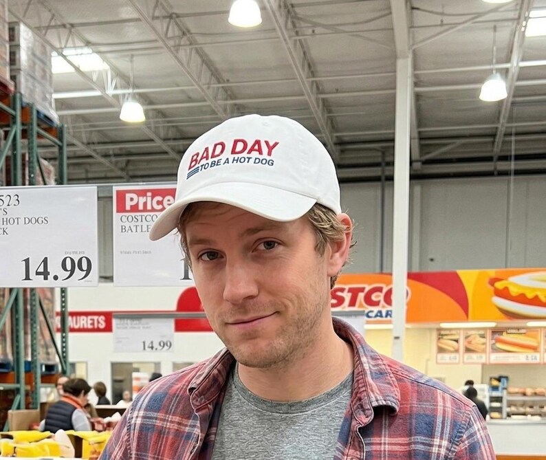 以下が含まれることがあります： 黒い持ち手と「But First, Coffee」の手書き風の文字が入った白いセラミックマグカップ。白い表面に置かれています。マグカップの高さは約10cmです。