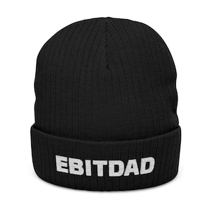 May include: Black ribbed knit beanie with the word "EBITDAD" embroidered in white block letters across the front. The beanie is a classic style, suitable for cold weather. The hat is made of a soft, warm material.