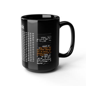 May include: Black ceramic mug with a white design featuring binary code and text. The text includes "The Times 03/Jan/2009 Chancellor on brink of second bailout for banks". The mug has a large handle.