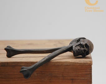 Par de quebra-nozes de ferro fundido do final do século XIX em formato de caveira e ossos cruzados.