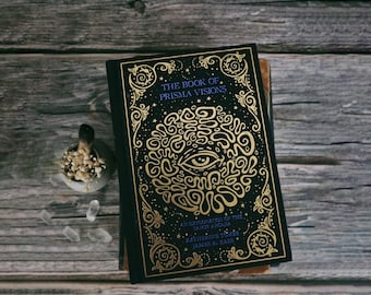 May include: A black book with a gold design featuring an eye and the text "The Book of Prisma Visions: An Exploration of the Tapot Arcana" by Katherine TỪMis and James R. Eads.