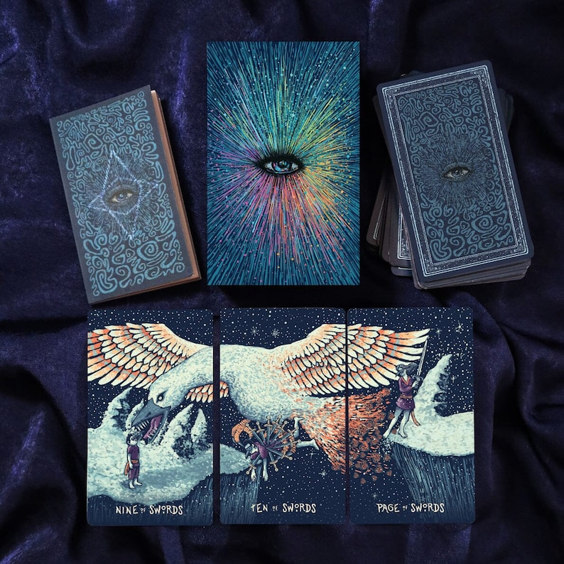May include: Three tarot cards from a deck featuring a dark blue background with a white, orange, and yellow bird with a large beak. The cards are titled "Nine of Swords", "Ten of Swords", and "Page of Swords".