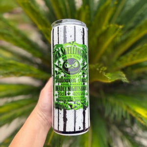 May include: A tall, cylindrical tumbler with a black and white striped pattern. The tumbler features a green and black label with the text "Jack Skellington Mold Time" and "Halloween Town". The label also includes the text "Deadly Nightshade" and "70cl 40%Vol".