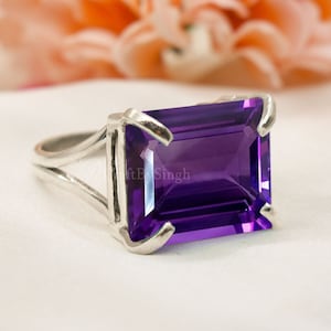 Könnte beinhalten: Ein silberner Ring mit einem großen, rechteckigen, violetten Amethyst-Edelstein. Der Ring hat ein schlichtes, elegantes Design.