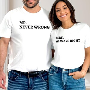 May include: Two white t-shirts with black text. One shirt reads "MR. NEVER WRONG", and the other reads "MRS. ALWAYS RIGHT". The shirts are paired with blue jeans.
