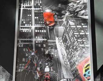 May include: Black and white illustration of a city skyline with two figures standing on a rooftop. The sky is filled with clouds and a red sun. The figures are wearing black clothing and have their backs to the viewer. The illustration is framed in a black frame with a silver border.