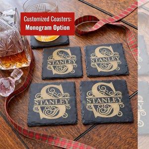 Pode incluir: Um conjunto de quatro bases quadradas de ardósia com um design de monograma dourado. Cada base apresenta o nome "STANLEY" e a letra "S". O texto "Customized Coasters: Monogram Option" está numa caixa vermelha.