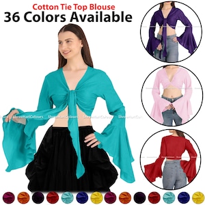Peut inclure: Un chemisier turquoise à nouer avec des manches longues et des manches bouffantes. Le chemisier est noué à l'avant et a un décolleté en V profond. Le mannequin porte une jupe noire et le chemisier est disponible en 36 couleurs.