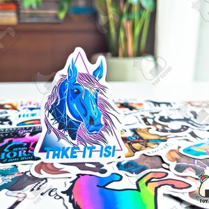 May include: A blue and purple horse head sticker with a triangle border and the text "TAKE IT ISI" on a white background. The sticker is surrounded by other stickers.