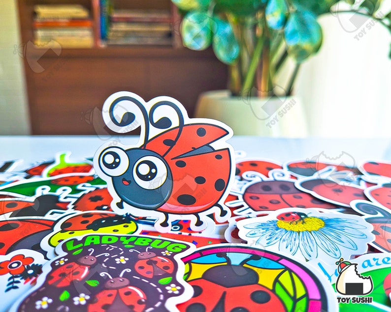 May include: A collection of ladybug stickers with various designs, including a cartoon ladybug with big eyes and a ladybug with a daisy. The stickers are printed on white paper and have a glossy finish.
