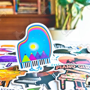 May include: A collection of colorful piano-themed stickers, including a sticker of a piano with a mountain scene and a sticker of a piano with the text "Piano Girl".
