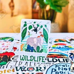 May include: A colorful sticker with a green, brown, and white illustration of a jungle scene with animals. The sticker says "Protect the Wildlife" in green letters.