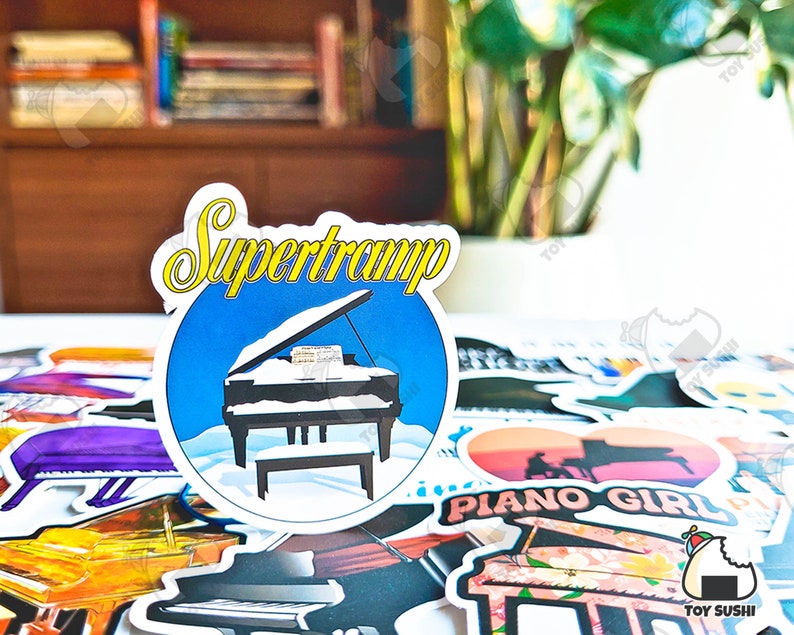 May include: A sticker with a blue background and a white grand piano with the text "Supertramp" in yellow letters.