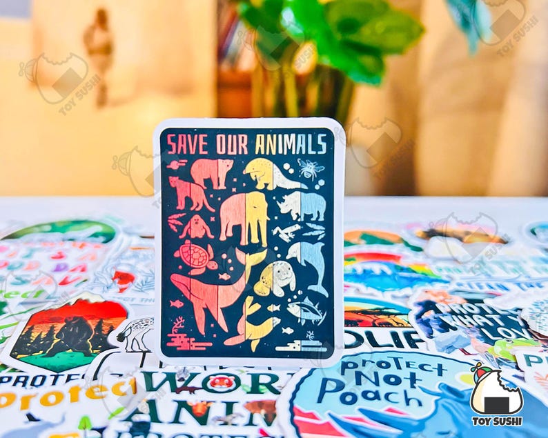 May include: A colorful sticker with the text "Save Our Animals" and illustrations of various animals, including a whale, a turtle, a bear, and a rhinoceros. The sticker is surrounded by other stickers with various designs.