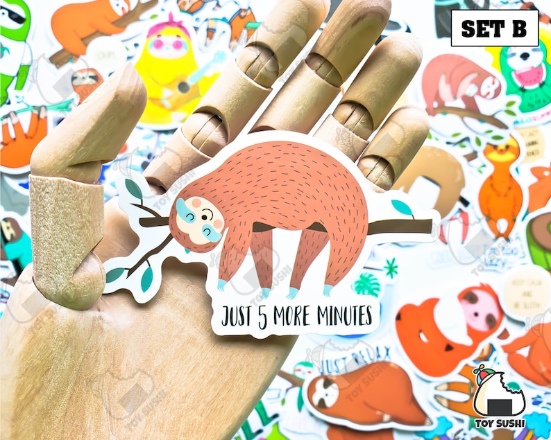 May include: A set of colorful sloth stickers with various designs. One sticker features a sloth hanging from a branch with the text "Just 5 more minutes". The set is labeled "Set B".