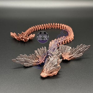 Puede incluir: Una figura de dragón impresa en 3D de color cobre con alas y una cola larga. El dragón está en posición enroscada con la cabeza levantada. La figura está hecha de un material detallado y texturizado.