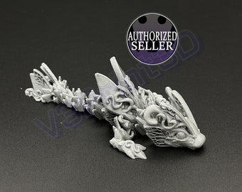 May include: A silver 3D printed model of a stylized dragon with intricate details. The dragon is lying on its belly with its head turned to the side.