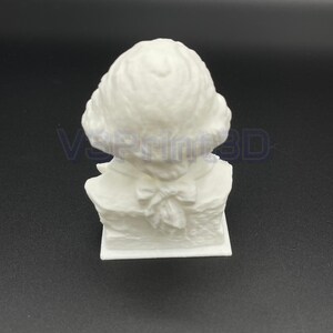 May include: White 3D printed bust sculpture of a person with a bow tie and a detailed hairstyle.