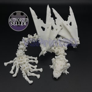 Puede incluir: Esqueleto de dragón blanco impreso en 3D en plástico con alas, cola y cabeza. El dragón está en posición de pie con las alas extendidas.