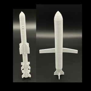 May include: Two white 3D printed model rockets. The rocket on the left has four fins at the bottom and a single fin at the top. The rocket on the right has two large wings and a single fin at the bottom.
