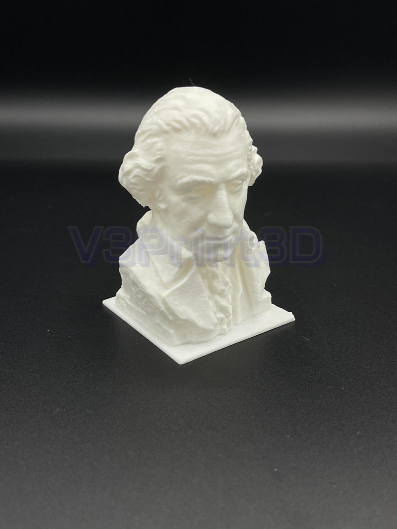 May include: A white 3D printed bust of a man with a short, curly wig. The bust is on a white base.