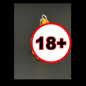 May include: A yellow keychain with a red circle and the text "18+" in black.