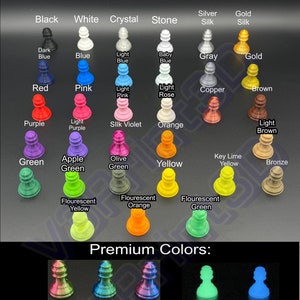 May include: A chart of chess pieces in various colors, including black, white, crystal, stone, silver silk, gold silk, dark blue, blue, light blue, baby blue, gray, gold, red, pink, light pink, light rose, copper, brown, purple, light purple, silk violet, orange, light brown, green, apple green, olive green, yellow, key lime yellow, bronze, fluorescent yellow, fluorescent orange, and fluorescent green. The chart also includes premium colors such as silk red/green, silk blue/green, silk red/blue, glow in the dark green, and glow in the dark blue. The text "V3Print3D" is at the top of the chart. The text "Premium Colors" is below the chart. The text "***PLEASE NOTE: Due to screen display variations, colors on screen may not reflect exact color match.***" is at the bottom of the chart.