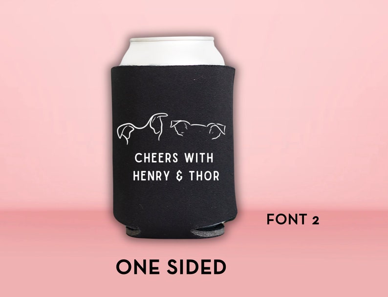 Peut inclure: Glaci&egrave;re en n&eacute;opr&egrave;ne noire avec du texte blanc qui dit "Cheers with Henry & Thor" et un dessin au trait de trois chiens. La glaci&egrave;re est unilat&eacute;rale et porte le texte "FONT 2" imprim&eacute; en dessous.