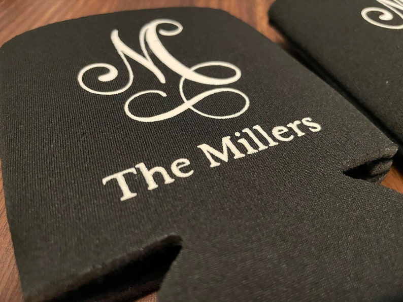 Peut inclure: Glaci&egrave;re en n&eacute;opr&egrave;ne noire avec inscription brod&eacute;e blanche "The Millers" et un monogramme "MC".