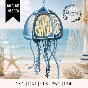 May include: A light blue paper jellyfish lantern featuring intricate star cutouts and hanging tentacles. The structure is illuminated from within by warm string lights. Text on the image reads NO GLUE NEEDED and Dreaming SVG, with SVG | DXF | EPS | PNG | PDF at the bottom.