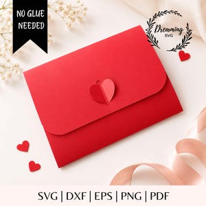 Op de afbeelding: Een felrode papieren envelop met een hartvormige sluiting. De envelop wordt getoond met een zwarte banner met de witte tekst NO GLUE NEEDED en een logo met de tekst Dreaming SVG. Kleine rode hartvormige uitsparingen zijn aanwezig.