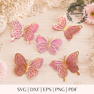 Könnte beinhalten: Fünf mehrlagige Schmetterlingsausschnitte mit einer soliden rosa Basisschicht und einer metallisch goldenen Filigran-Oberschicht. Der Text Dreaming SVG ist in der oberen rechten Ecke gedruckt. Die Schmetterlinge sind verstreut angeordnet.
