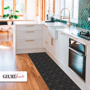 Op de afbeelding: Een zwarte en gouden geometrische keukenloper met een modern ontwerp. De loper ligt in een keuken met witte kasten en een oven van roestvrij staal.