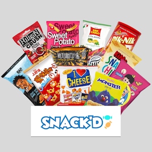May include: A selection of snack foods, including potato chips, pretzels, crackers, and cheese puffs. The bags are colourful and feature various designs, including a cartoon monster, a heart with the word "cheese", and a pizza slice. The bags are arranged in a basket with the word "SNACK'D" printed on the front.