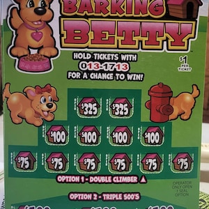 Op de afbeelding: Een groene kraslot met de titel "Barking Betty" in roze en geel. De loterij bevat cartoonhonden, hondenhokken en dollarbedragen. Tekst bevat "Houd tickets met 013-1713 vast voor een kans om te winnen!"