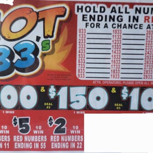 May include: A red and yellow scratch card with the text "HOT 33's". The card features various numbers, prize amounts, and the phrase "Hold All Numbers Ending in Red 33" for a chance to win.