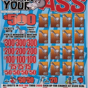 May include: A Pickin Your Ass lottery scratch-off game card featuring a cartoon donkey head and sixteen numbered scratch-off windows. The card displays various dollar amounts in red text, instructions for winning, and a list of digits from 100 to 2000.