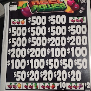 Può includere: Un biglietto gratta e vinci Reel Power in bianco e nero con vari importi dei premi in testo bianco. Il biglietto presenta illustrazioni di frutta e il testo "REEL POWER" in alto.