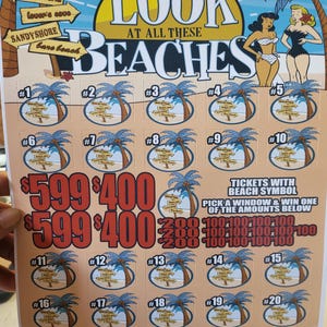 Könnte beinhalten: Ein farbenfrohes Rubbellos mit dem Text "LOOK AT ALL THESE BEACHES". Das Los zeigt Palmen, Strandszenen und verschiedene Gewinnbeträge. Der Text "$1 PER PLAY" ist ebenfalls vorhanden.