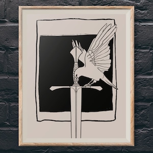 Può includere: Stampa artistica incorniciata con un'illustrazione in bianco e nero di un uccello su una spada. L'uccello ha le ali spiegate e la spada è posta su uno sfondo nero. L'opera d'arte è incorniciata in una cornice color legno chiaro.
