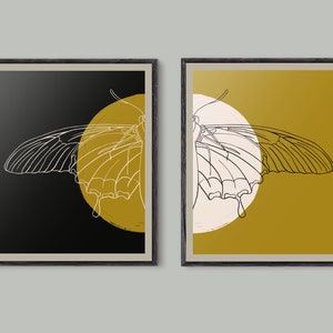 Può includere: Due stampe artistiche incorniciate. Ognuna presenta un disegno a tratto bianco di un'ala di farfalla contro un cerchio giallo. Uno sfondo è nero, l'altro giallo senape. Le cornici sono in legno scuro.
