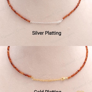 May include: Two necklaces with small, round, reddish-brown beads. One necklace has silver plating, and the other has gold plating. The text "Silver Plating" and "Gold Plating" are below each necklace.