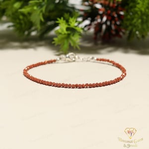 Peut inclure: Une tasse en céramique blanche avec une anse noire et le texte "But First, Coffee" dans un style manuscrit. La tasse est posée sur une surface blanche. La tasse mesure environ 10 cm de haut.